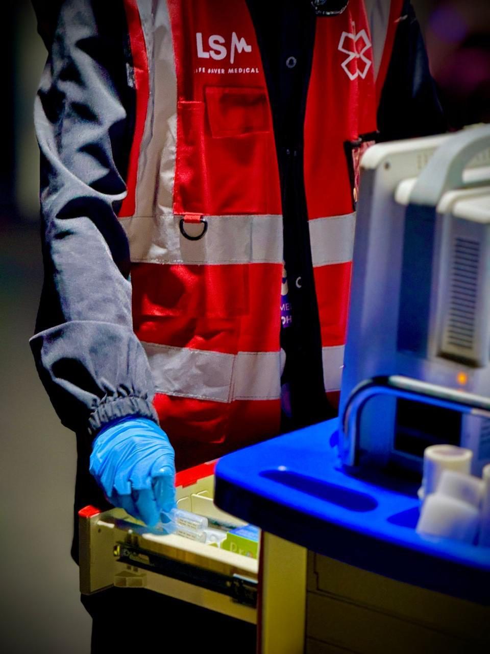 LSM paramedic in a red LSM vest preparing medical equipment